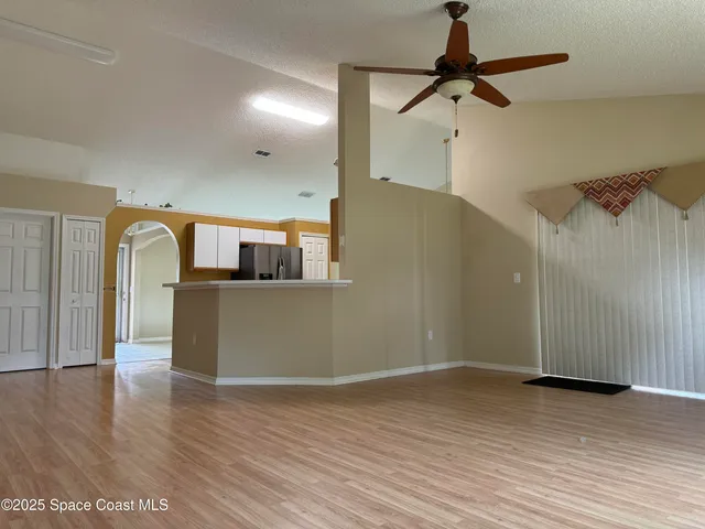a view of a room with wooden floor and white walls