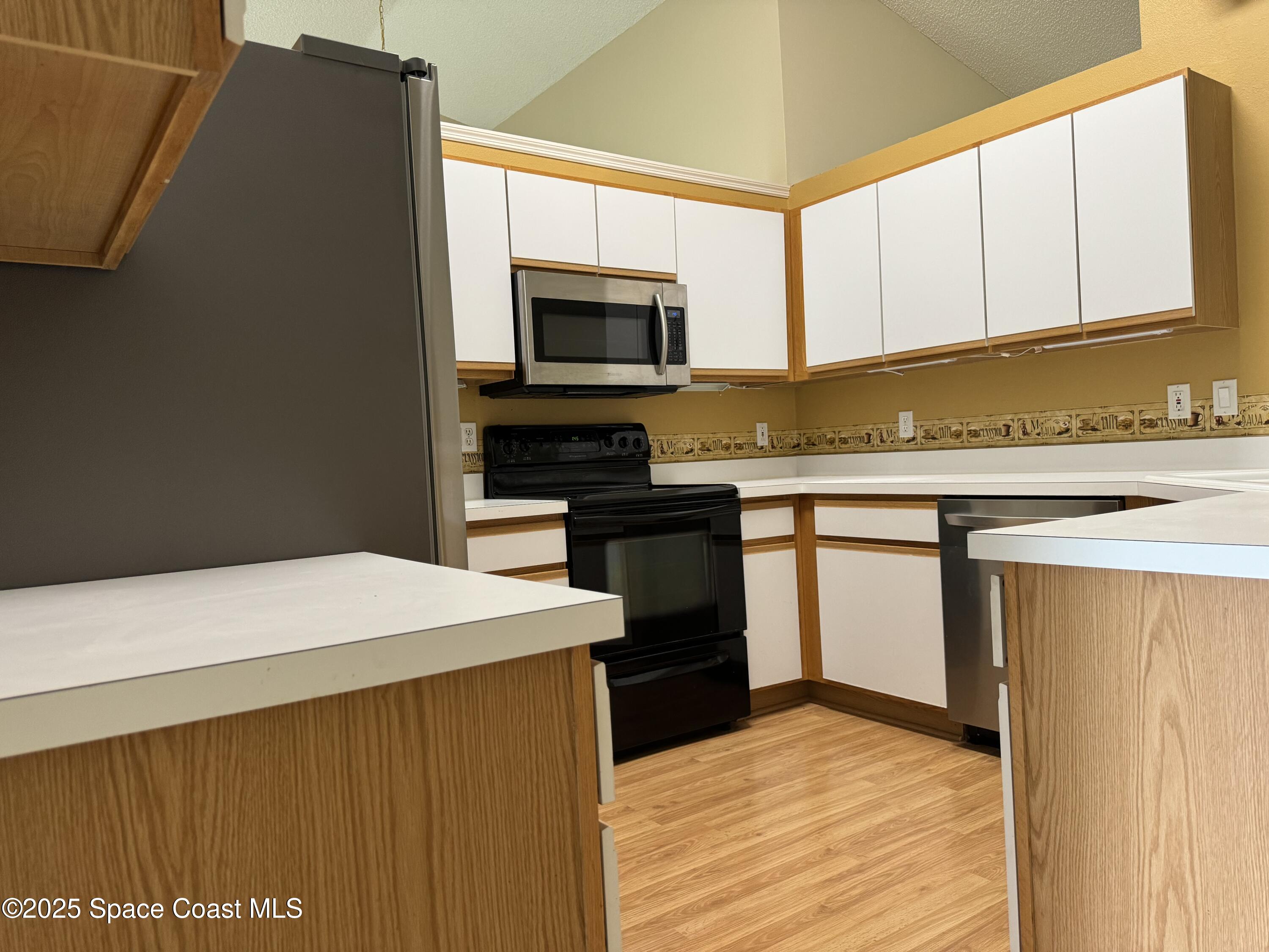 Undisclosed Address Palm Bay, FL 32909 - Photo 10 of 20 a kitchen with stainless steel appliances a microwave a stove and white cabinets