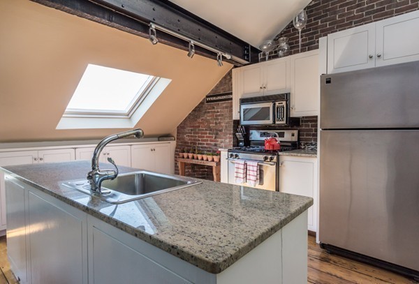 a kitchen with stainless steel appliances granite countertop a sink dishwasher and a refrigerator