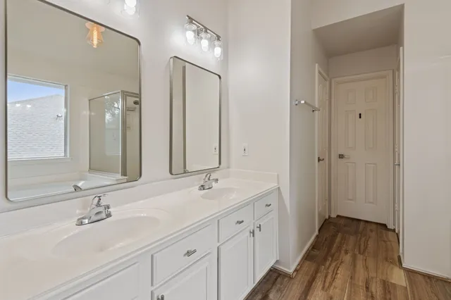 a bathroom with double vanity sinks and a mirror