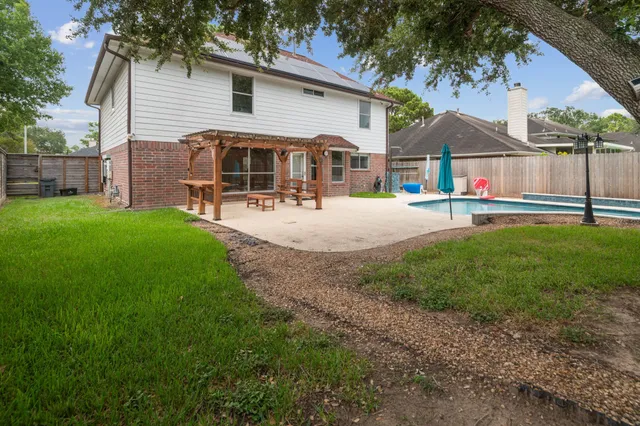 a view of a house with backyard and sitting area