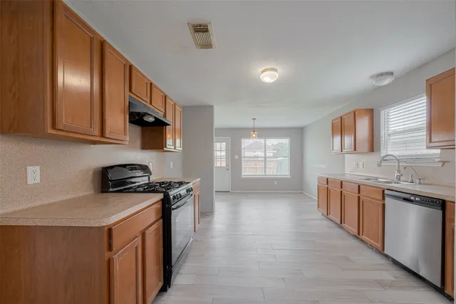 a kitchen with stainless steel appliances granite countertop a stove a sink and a microwave