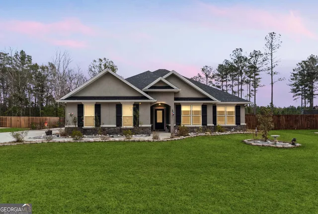 a front view of a house with a garden and trees