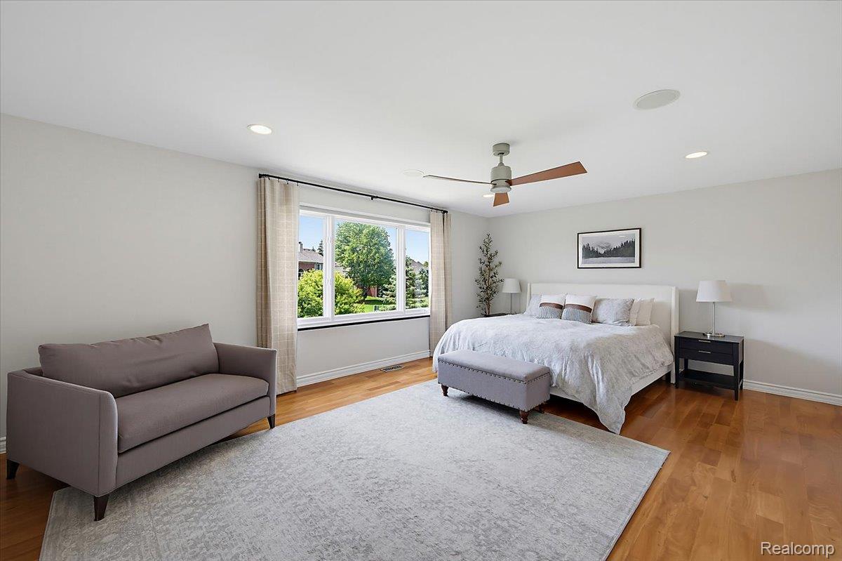1422 Galena Rochester, MI 48306 - Photo 27 of 73 Spacious bedroom featuring light-toned walls, hardwood flooring, and a large multi-pane window with exterior landscaping visible
