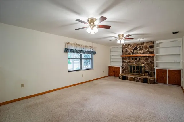 a view of a livingroom with a fireplace window and a ceiling fan