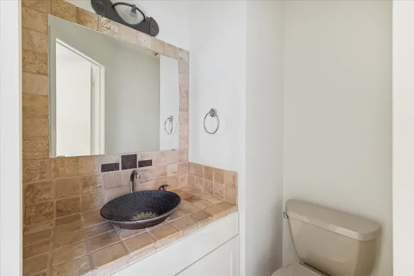 a bathroom with a granite countertop sink and a mirror
