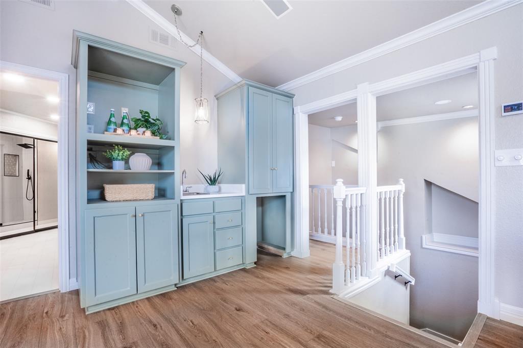1415 Pecos Street Dallas, TX 75204 - Photo 6 of 25 a kitchen with white cabinets and wooden floor