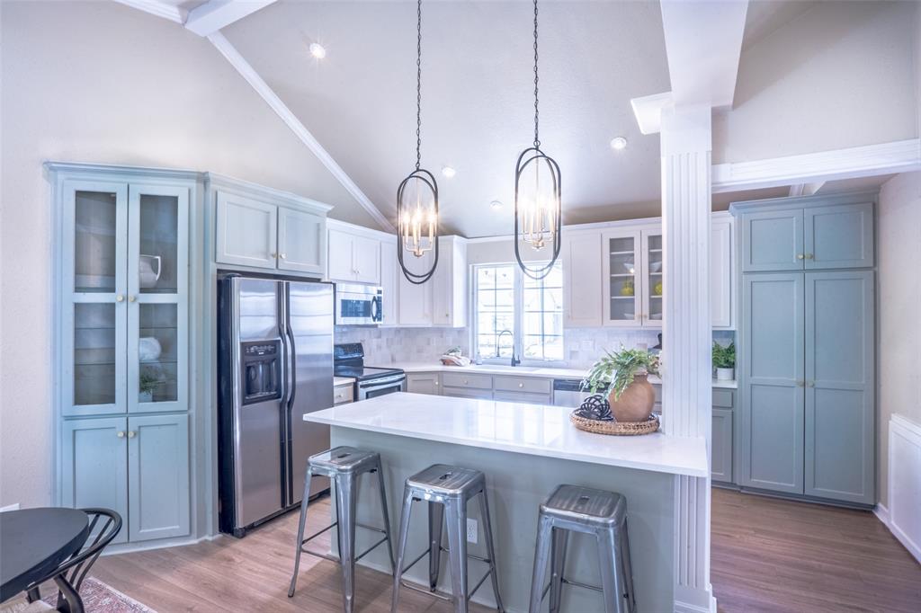 1415 Pecos Street Dallas, TX 75204 - Photo 8 of 25 a kitchen with stainless steel appliances a dining table chairs cabinets and wooden floor