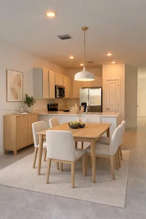 a dining room with a table chairs and a kitchen view