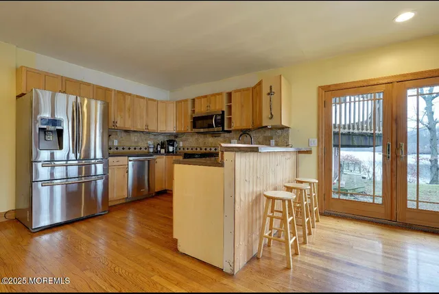 a kitchen with stainless steel appliances granite countertop a stove top oven a sink and a refrigerator