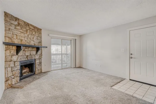 a view of an empty room with a fireplace and a window