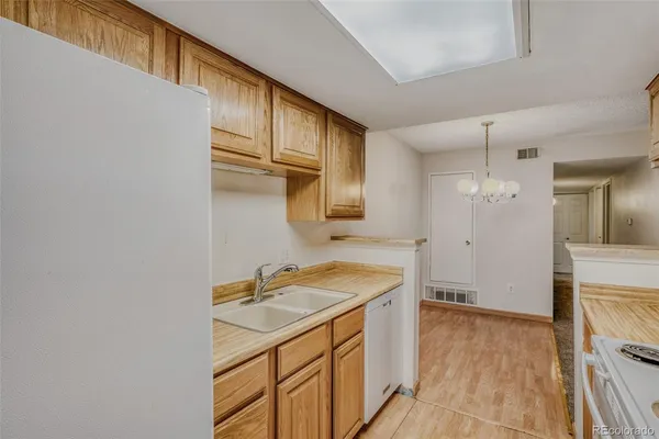 a kitchen with stainless steel appliances granite countertop a refrigerator a stove and a sink