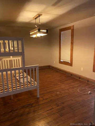 a view of an empty room with wooden floor and a cabinet