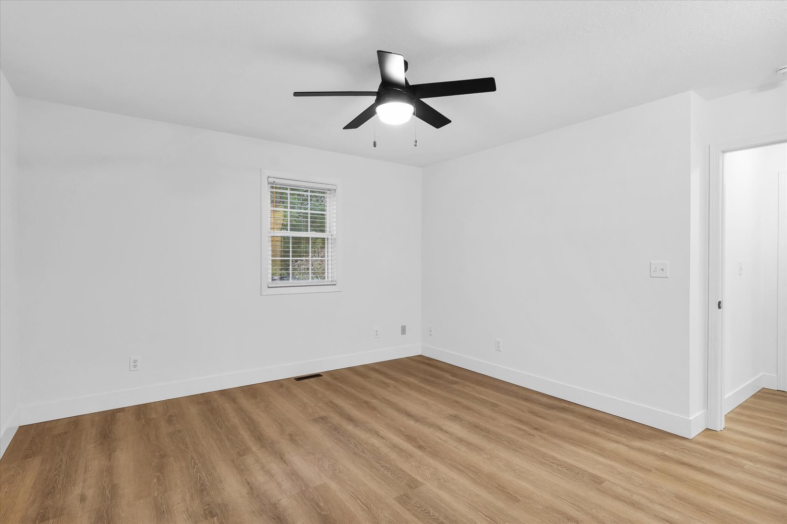 203 West Main Street Ogden, IL 61859 - Photo 12 of 27 an empty room with wooden floor ceiling fan and windows