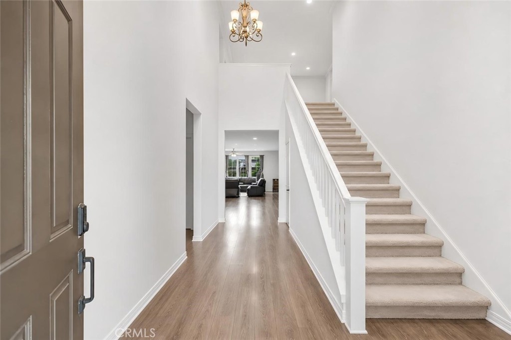 3380 Pine Ridge Loop Ontario, CA 91761 - Photo 2 of 37 a view of a hallway with wooden floor and staircase