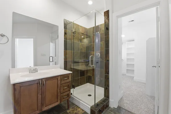 a bathroom with a sink shower and a mirror
