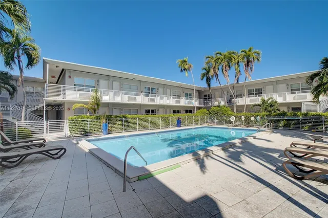 a view of a swimming pool with a lounge chairs in patio
