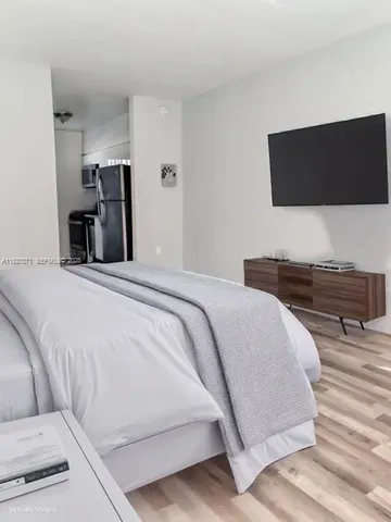 a bedroom with a bed and a flat screen tv