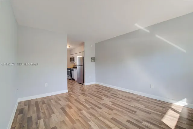 a view of empty room with wooden floor