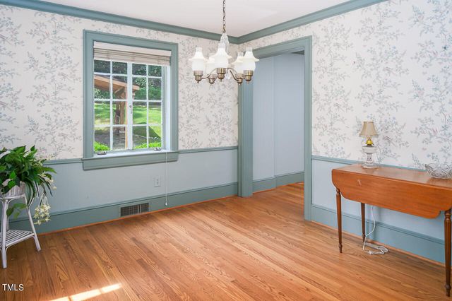 a view of a room with a chandelier and wooden floor