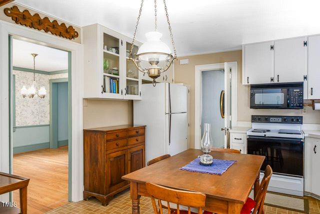 a kitchen with stainless steel appliances granite countertop a sink dishwasher and white cabinets with wooden floor