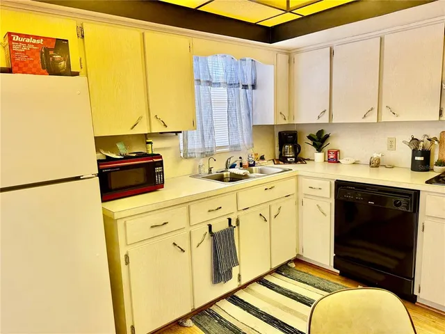 a kitchen with stainless steel appliances a stove a sink and a refrigerator with white cabinets