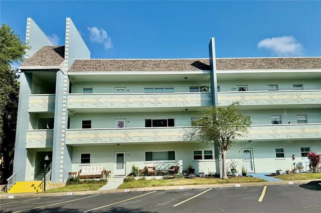 a view of a building with a space and a car park in front of it