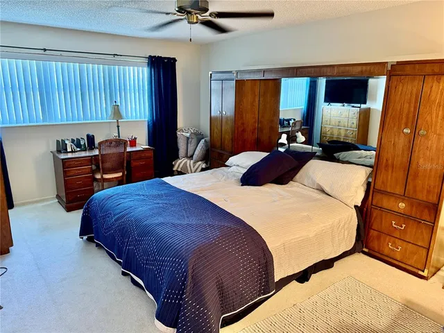 a bedroom with a bed and dresser with mirror