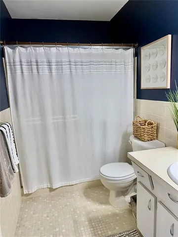 a bathroom with a toilet and a shower curtain