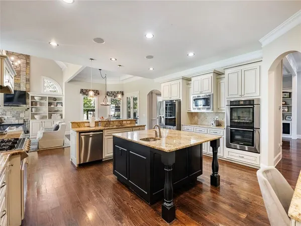 a kitchen with granite countertop a stove cabinets and wooden floor