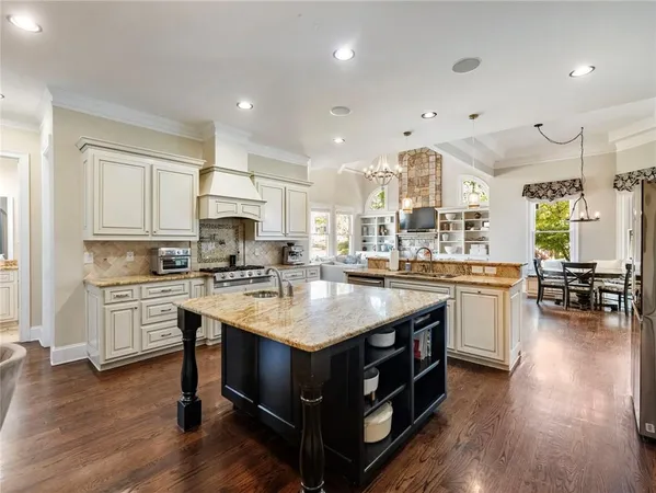 a kitchen with stainless steel appliances granite countertop a refrigerator a stove top oven and white cabinets