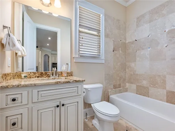 a spacious bathroom with a granite countertop tub sink and mirror