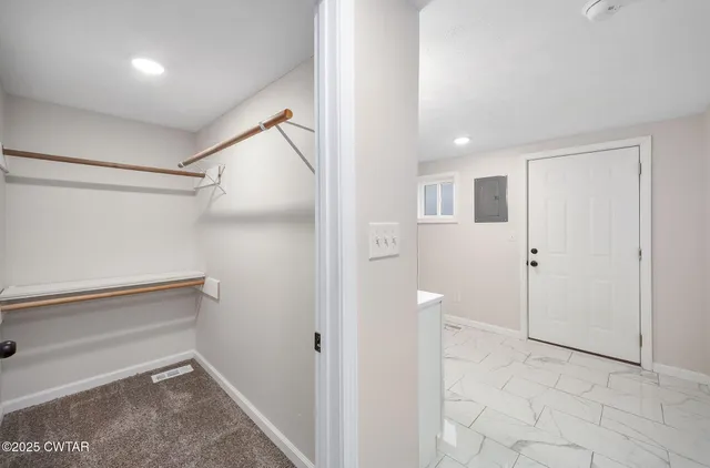 a view of a hallway with closet and bathroom