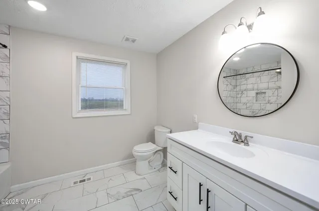 a bathroom with a sink mirror and toilet