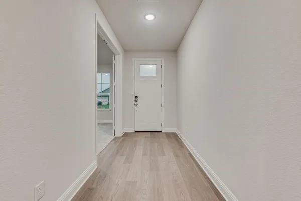a hall with a sink and a mirror
