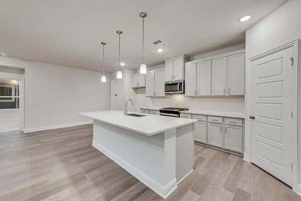 a kitchen with kitchen island a sink stainless steel appliances and cabinets