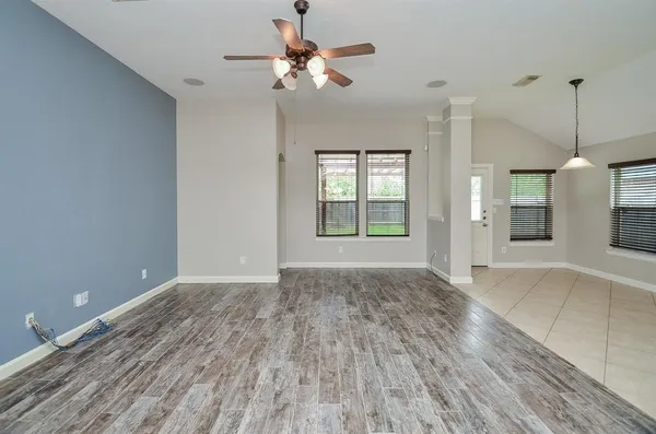 a view of an empty room with window and wooden floor