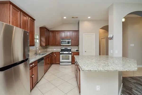 a kitchen with stainless steel appliances granite countertop a refrigerator stove and oven