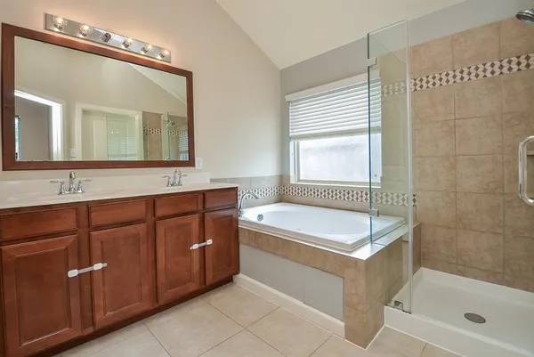 a bathroom with a tub sink and mirror
