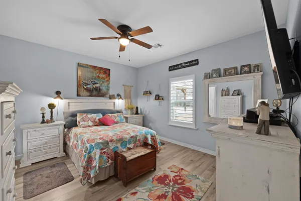 a bedroom with a bed a flat screen tv and a dresser