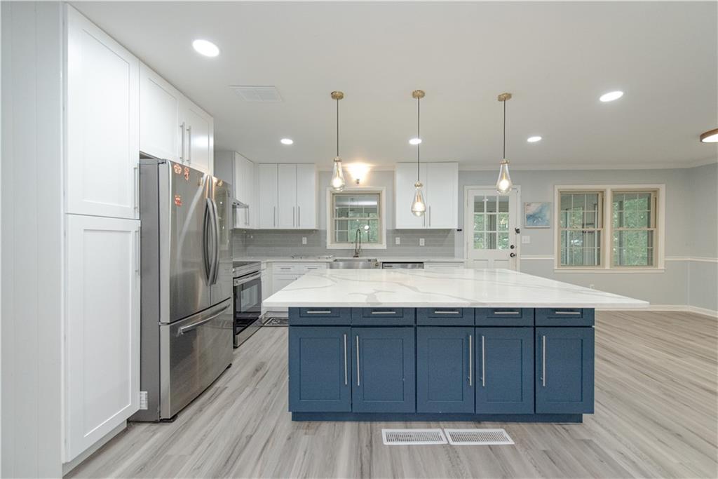 2702 Davenport Road Northwest Duluth, GA 30096 - Photo 11 of 32 a kitchen with a sink stainless steel appliances and wooden floor