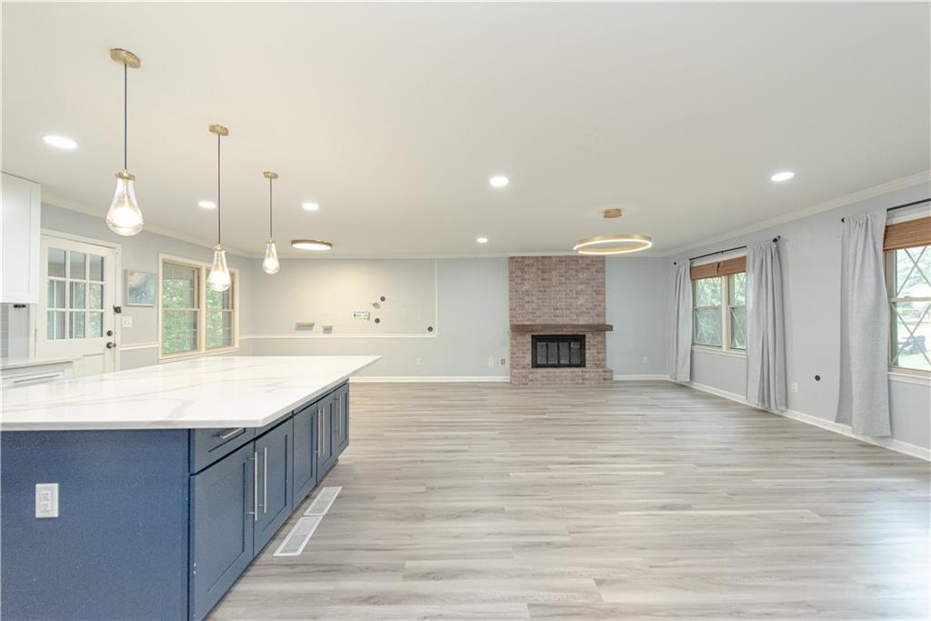 2702 Davenport Road Northwest Duluth, GA 30096 - Photo 13 of 32 a large kitchen with kitchen island a stove a sink a center island and wooden floor