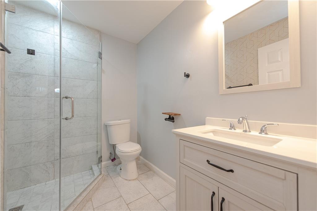 2702 Davenport Road Northwest Duluth, GA 30096 - Photo 28 of 32 a bathroom with a sink a toilet and a mirror