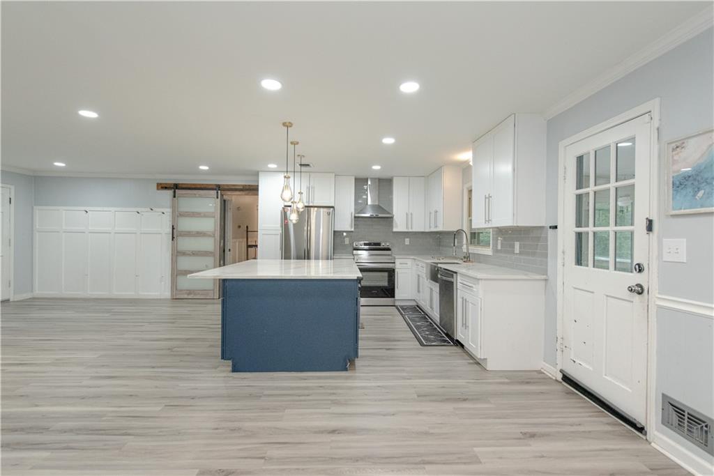 2702 Davenport Road Northwest Duluth, GA 30096 - Photo 8 of 32 a large kitchen with kitchen island a sink a center island stainless steel appliances and a cabinets
