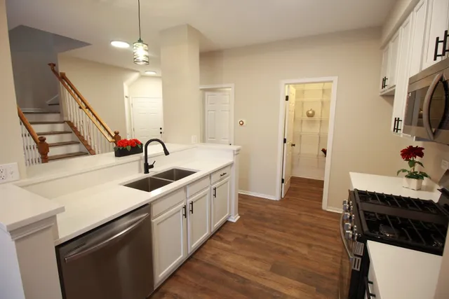 a kitchen with sink a microwave and cabinets