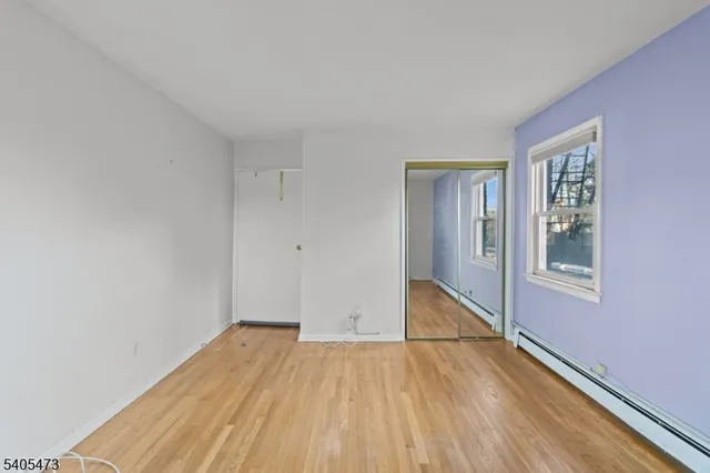 a view of a room with wooden floor and white walls
