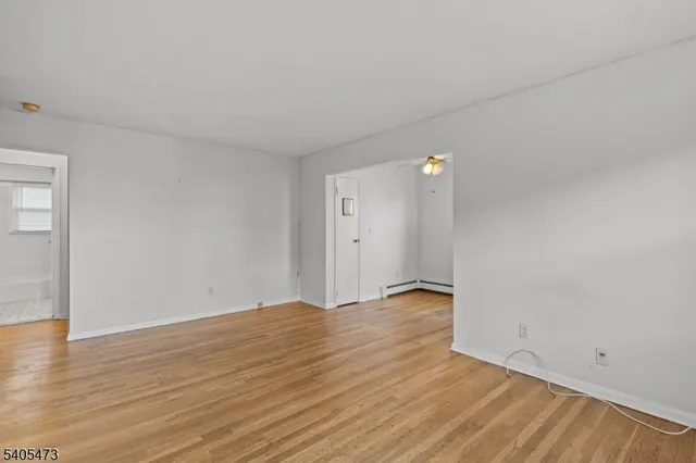 a view of an empty room with wooden floor
