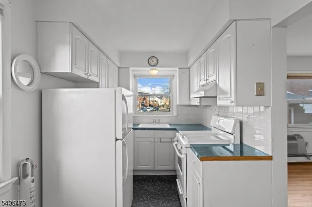 a kitchen with a sink a refrigerator a stove and cabinets