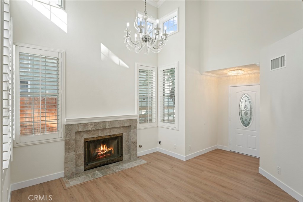 2405 Highland Pines Road Pomona, CA 91767 - Photo 7 of 32 a view of a livingroom with a fireplace a chandelier and windows