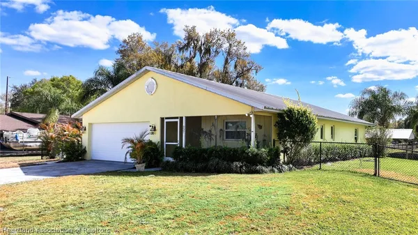 a front view of house with yard and trees in the background